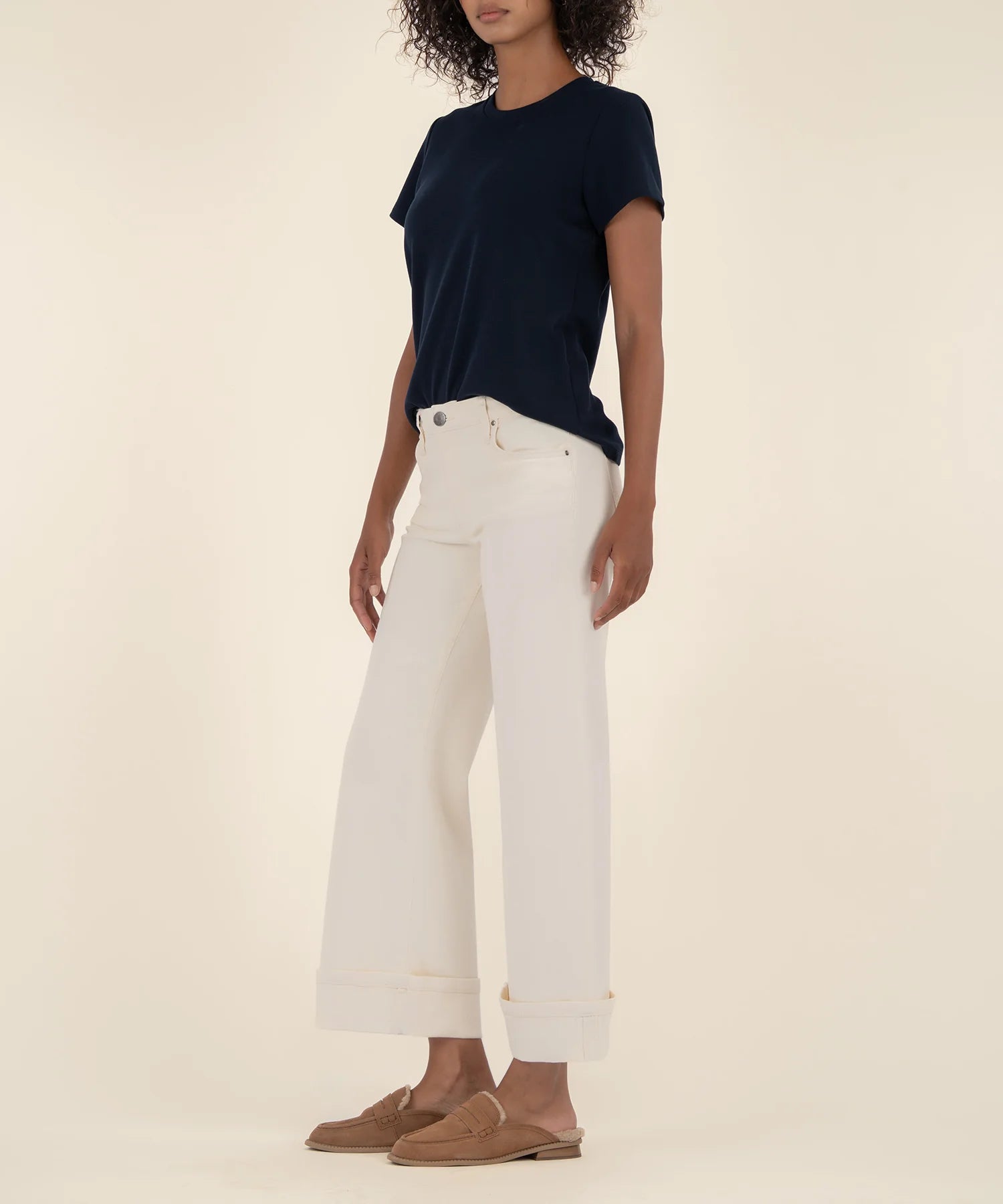 woman modeling the high rise wide leg denim with a bottom cuff in the color candle (ecru)