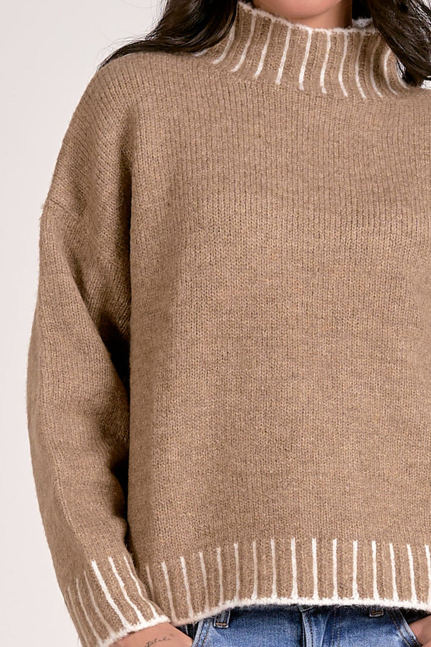 details of tan mock neck sweater with white whipstitch 