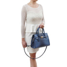model holding the virginia satchel handbag by the handles