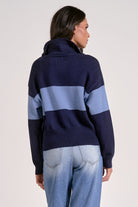 Person wearing quarter zip color block sweater navy and light blue stripe back view
