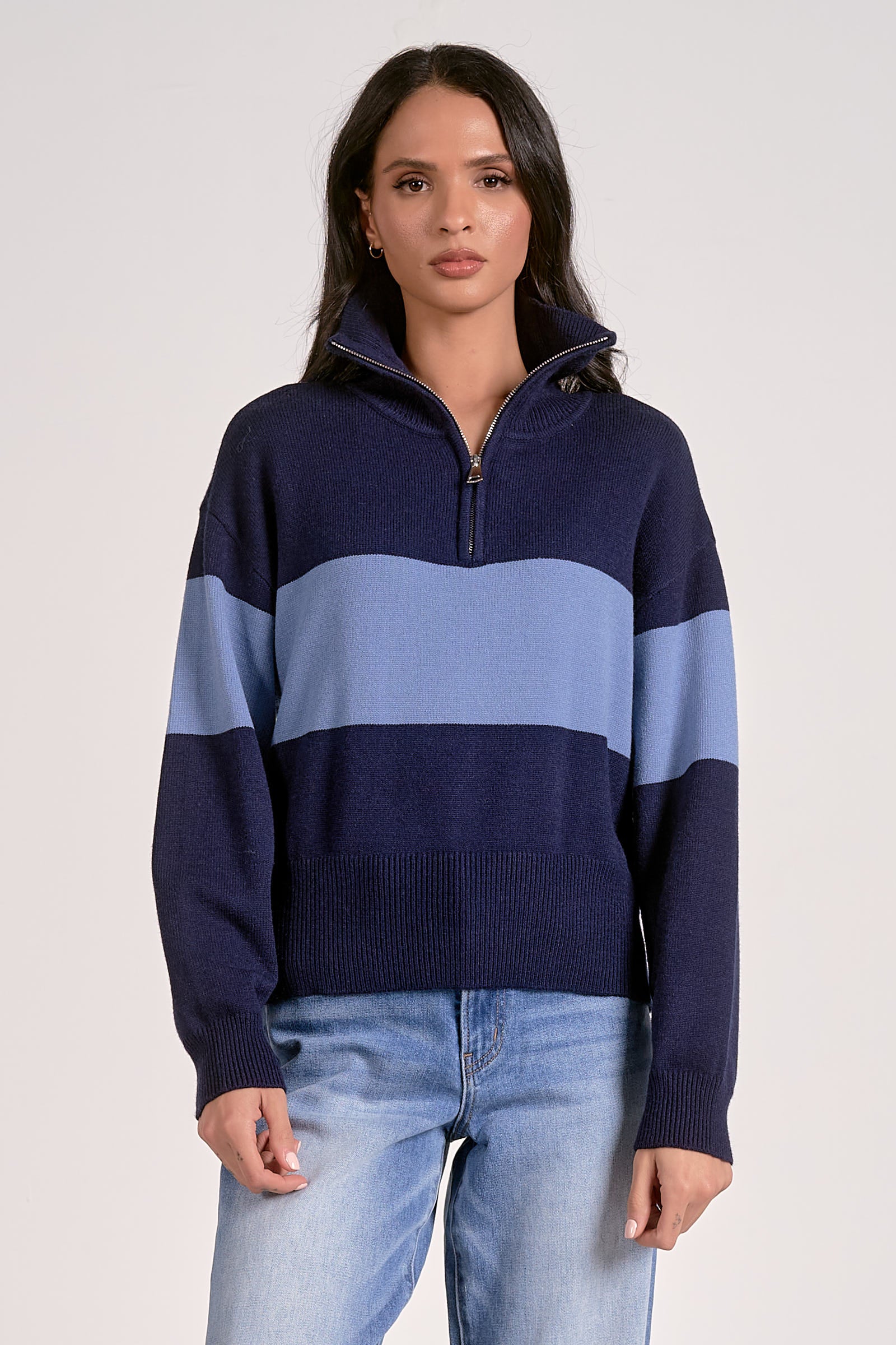 Woman wearing a quarter zip color block sweater in navy with a light blue stripe front view