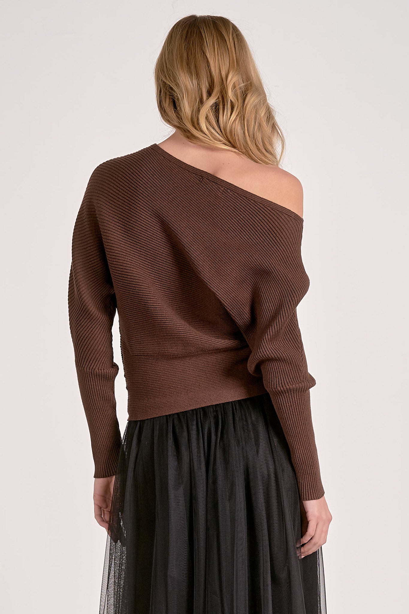 model showing back of dark chocolate off shoulder ribbed sweater with dolman sleeves