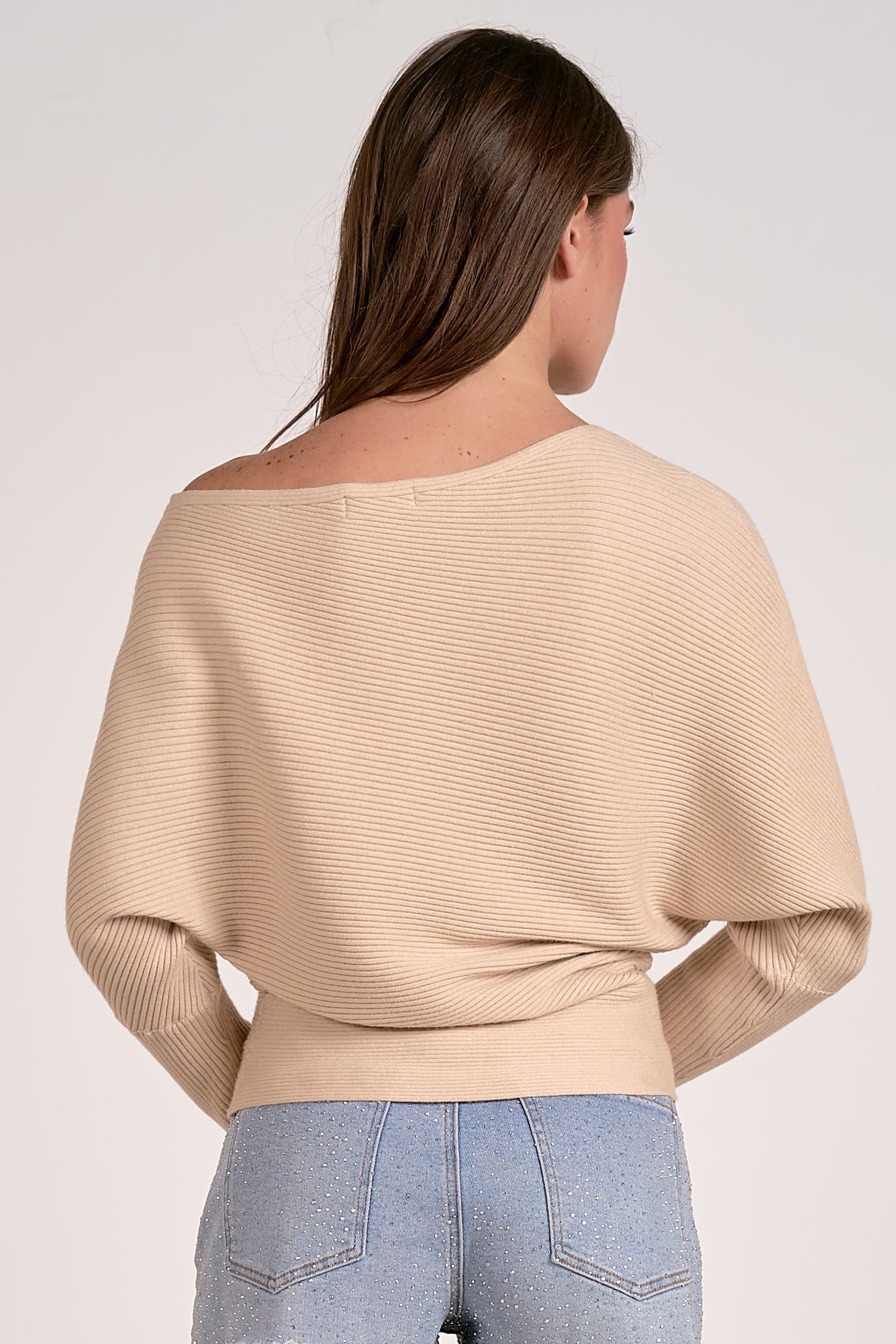 sand color off shoulder ribbed sweater styled with denim 