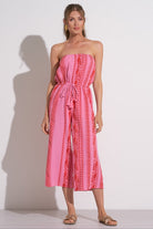 Woman wearing a pink and red vacation jumpsuit
