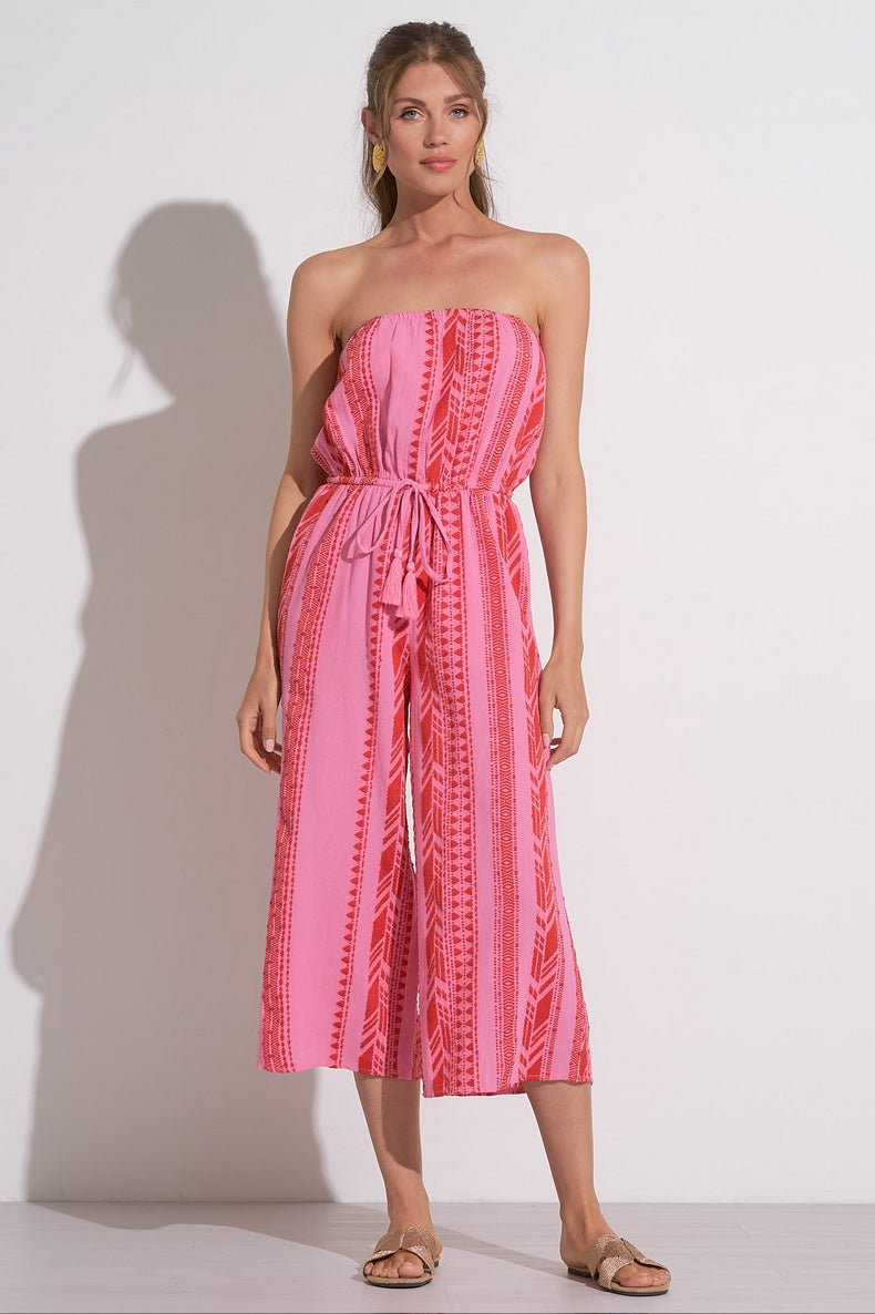 Woman wearing a pink and red vacation jumpsuit
