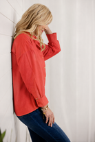 woman showing the side of red button down top