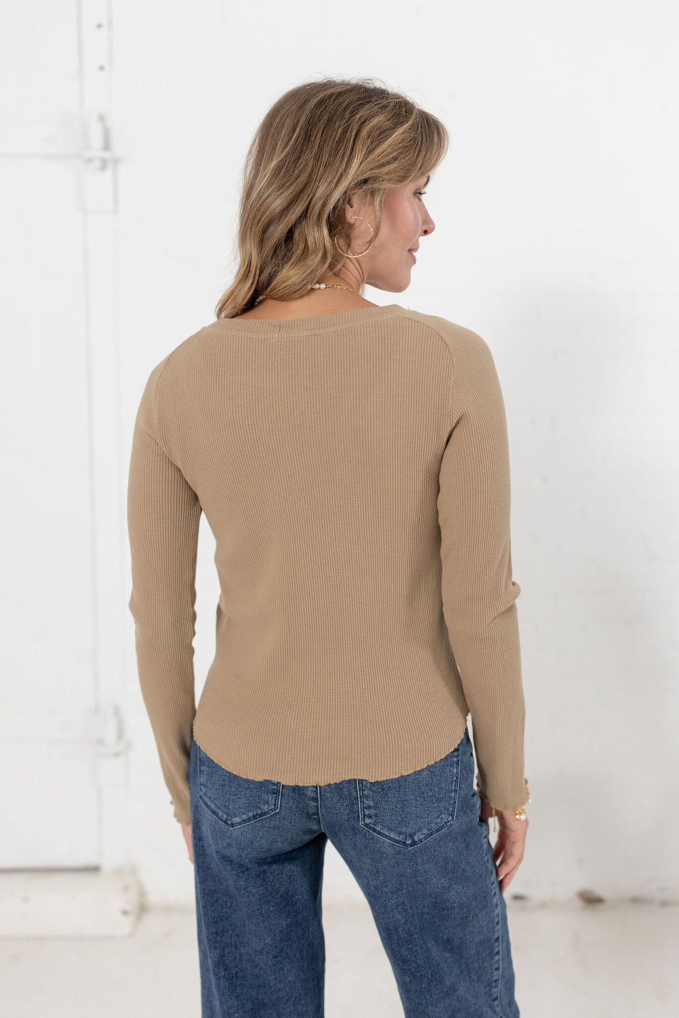 woman showing back of mac and me ribbed waffle top in tan with mac and me jeans