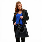 Woman holding the hobo-style vegan leather shoulder bag with pockets and adjustable strap in classic black