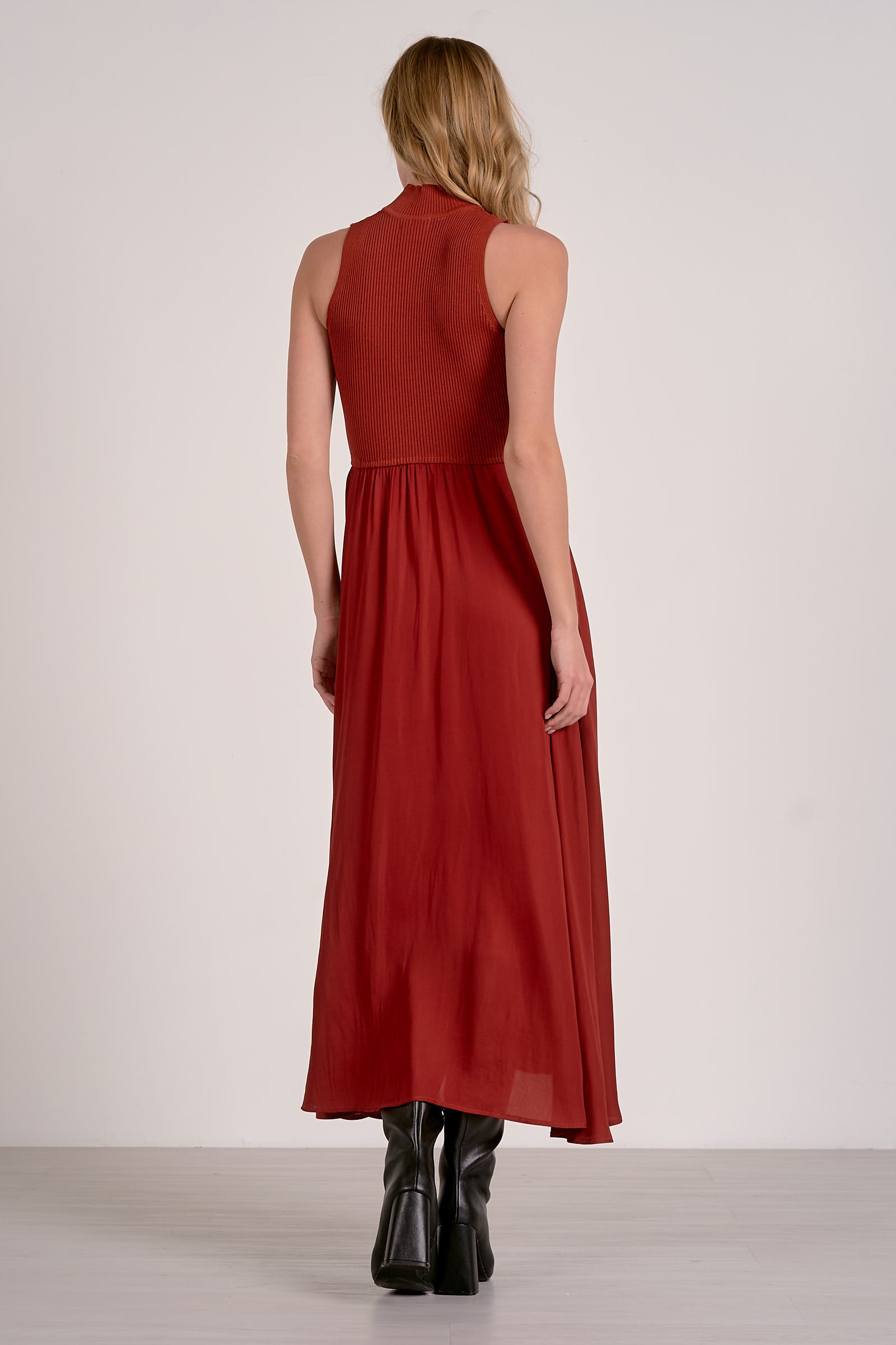 Back of the rust mockneck sleeveless maxi dress with ribbed bodice, woven skirt, and high-low hem from Mainstream Boutique Bloomington