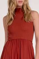 Details on rust mockneck sleeveless maxi dress with ribbed bodice, woven skirt, and high-low hem from Mainstream Boutique Bloomington