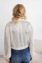 Woman showing the back of the Ivory Scarf Blouse with Gold Ring Detail from Mainstream Boutique Bloomington
