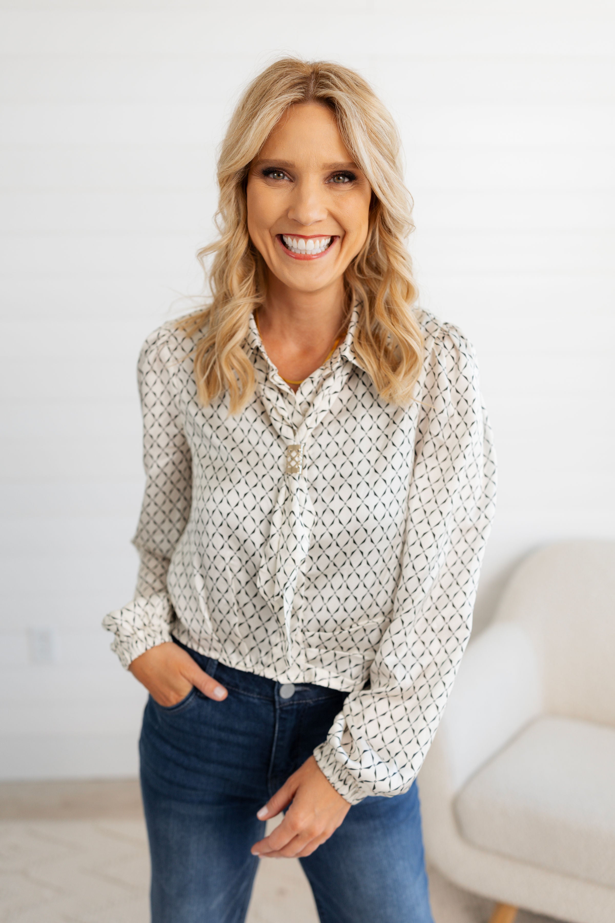 Woman wearing the Ivory Scarf Blouse with Gold Ring Detail from Mainstream Boutique Bloomington