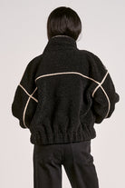 woman showing the back of the  black sherpa bomber jacket with contrast trim 