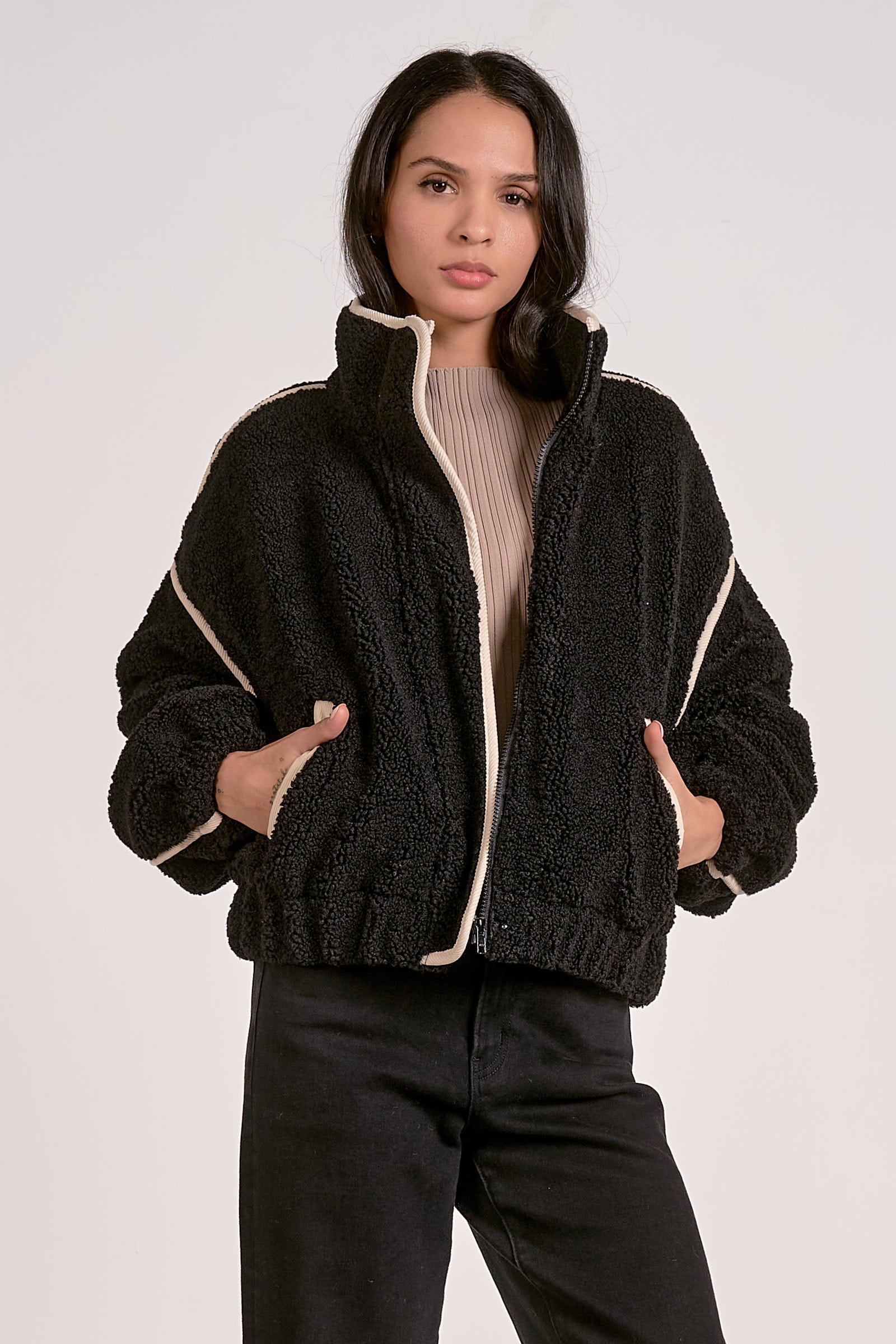 woman wearing a black sherpa bomber jacket with contrast trim 