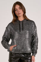 Model wearing silver Metallic Hoodie Sweater with relaxed fit and subtle shimmer from Mainstream Boutique Bloomington
