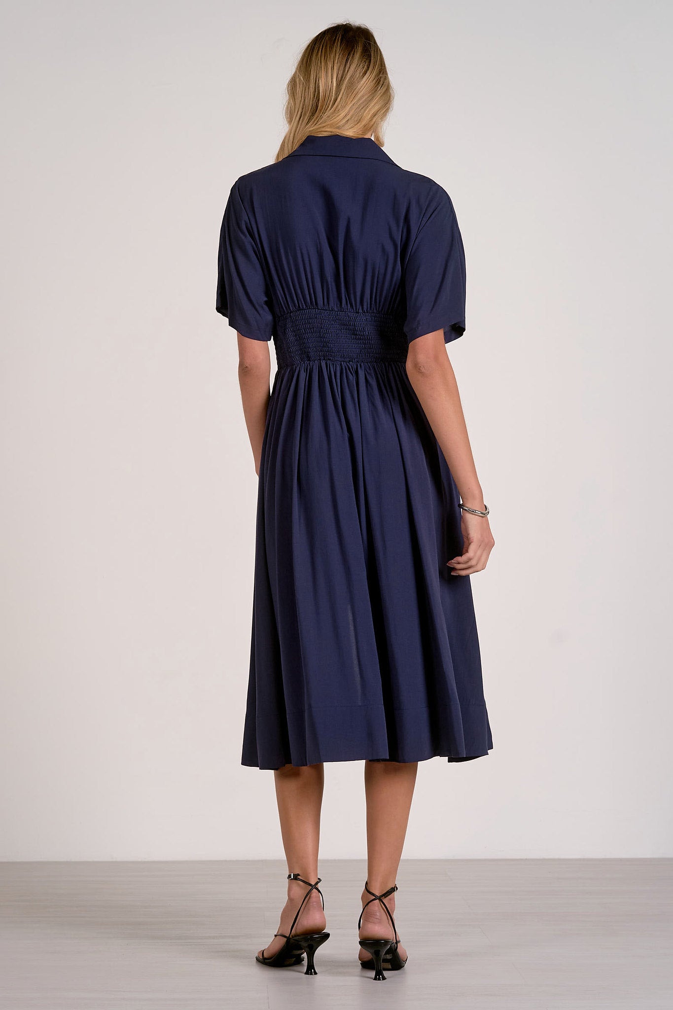 back view of navy smocked waist midi dress showing comfortable drape