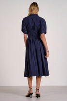 back view of navy smocked waist midi dress showing comfortable drape