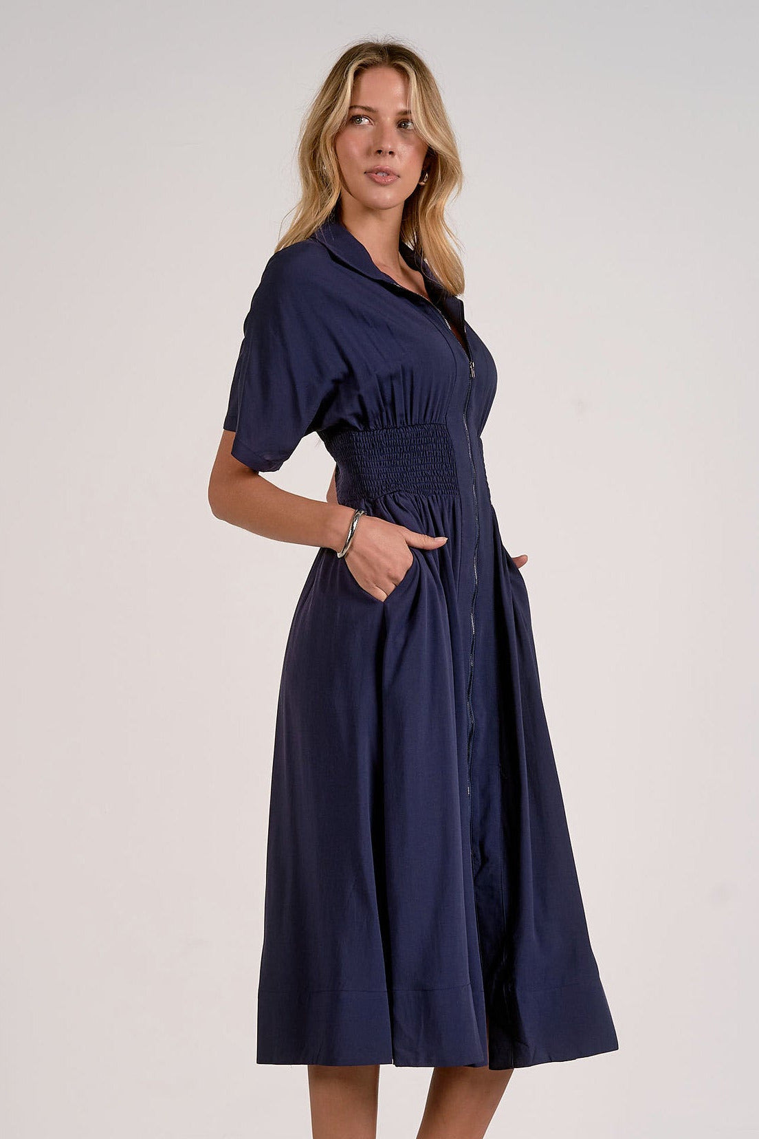 side view of navy smocked waist midi dress with relaxed skirt and flattering waist detail