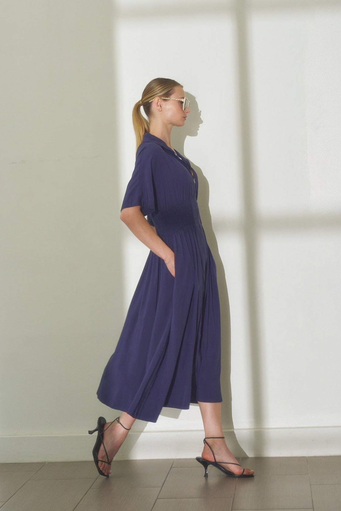 lifestyle photo of navy smocked waist midi dress showing comfortable drape
