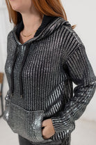 Model showing the details on the metallic knit sweater in silver from Mainstream Boutique Bloomington.