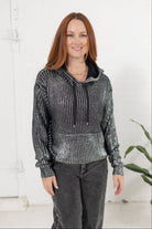 Model in metallic knit sweater in the color silver from Mainstream Boutique Bloomington.