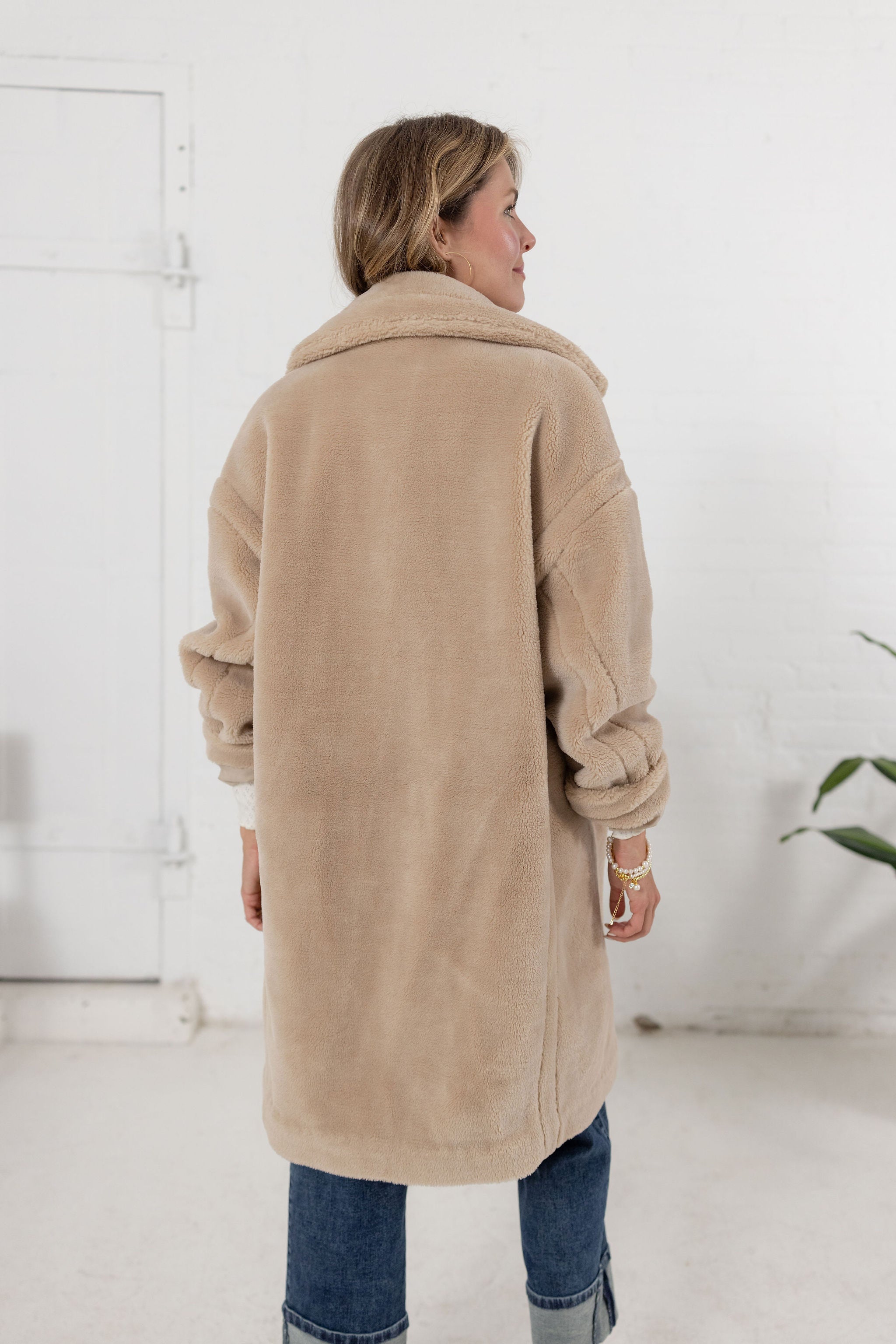 woman showing the back of the plush teddy coat from Mainstream Boutique Bloomington