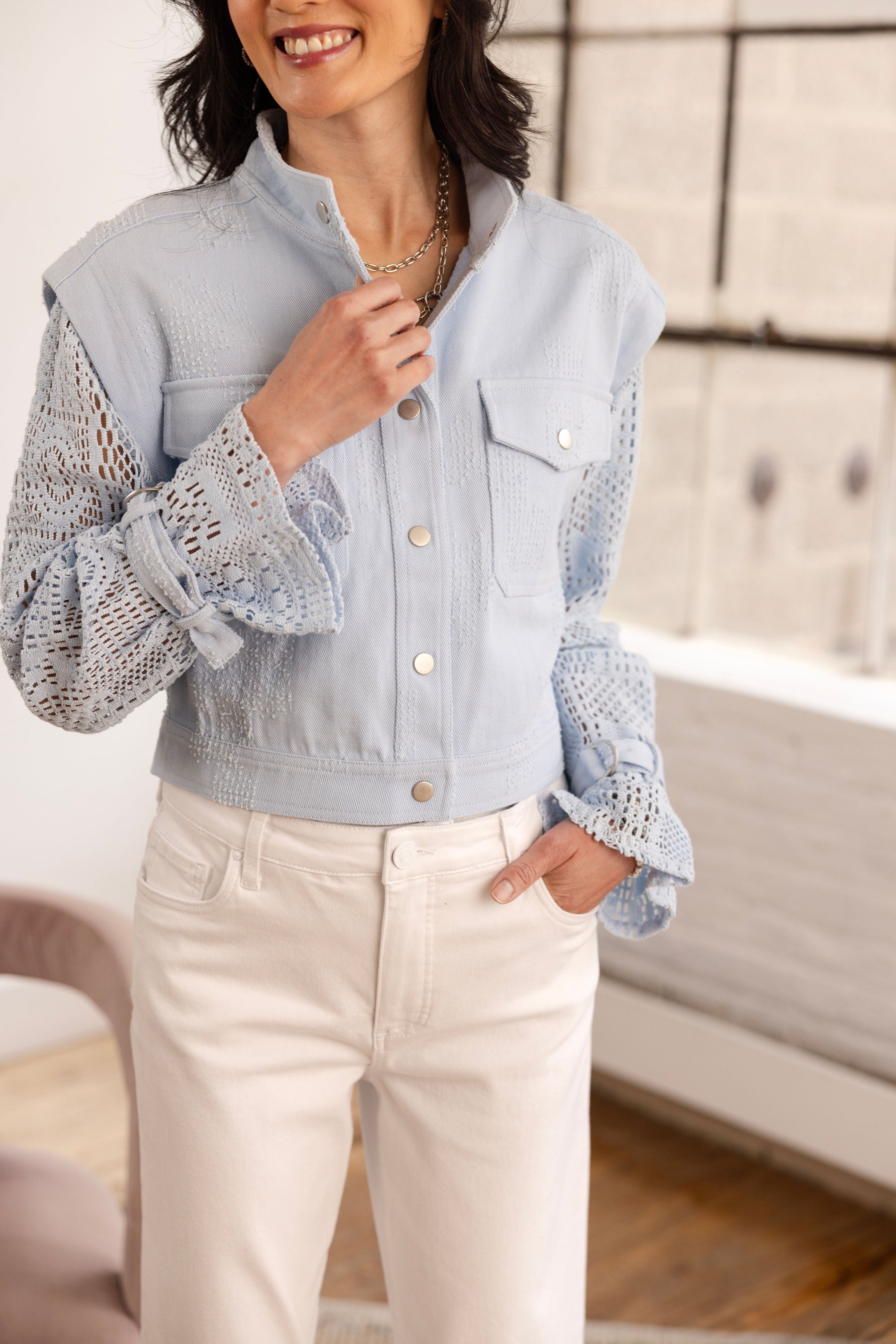 Denim jacket with crochet sleeves in blue breeze with white denim pants front view