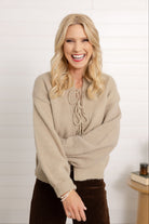 Woman showing the front of the tie front sweater in macchiato.