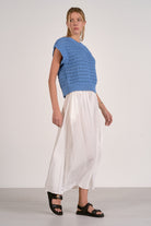 Vibrant blue textured open knit cap sleeve sweater with ribbed trim shown with white skirt and sandals