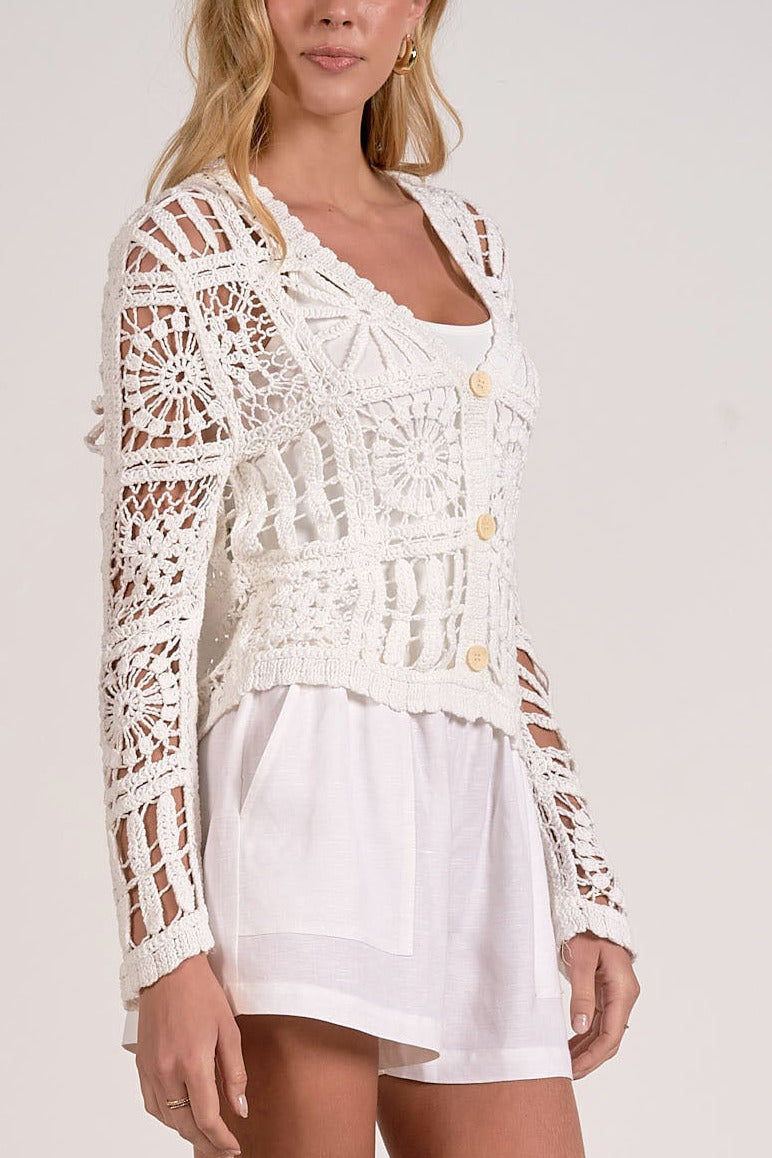 detail on white crochet cardigan with button front and open knit detail