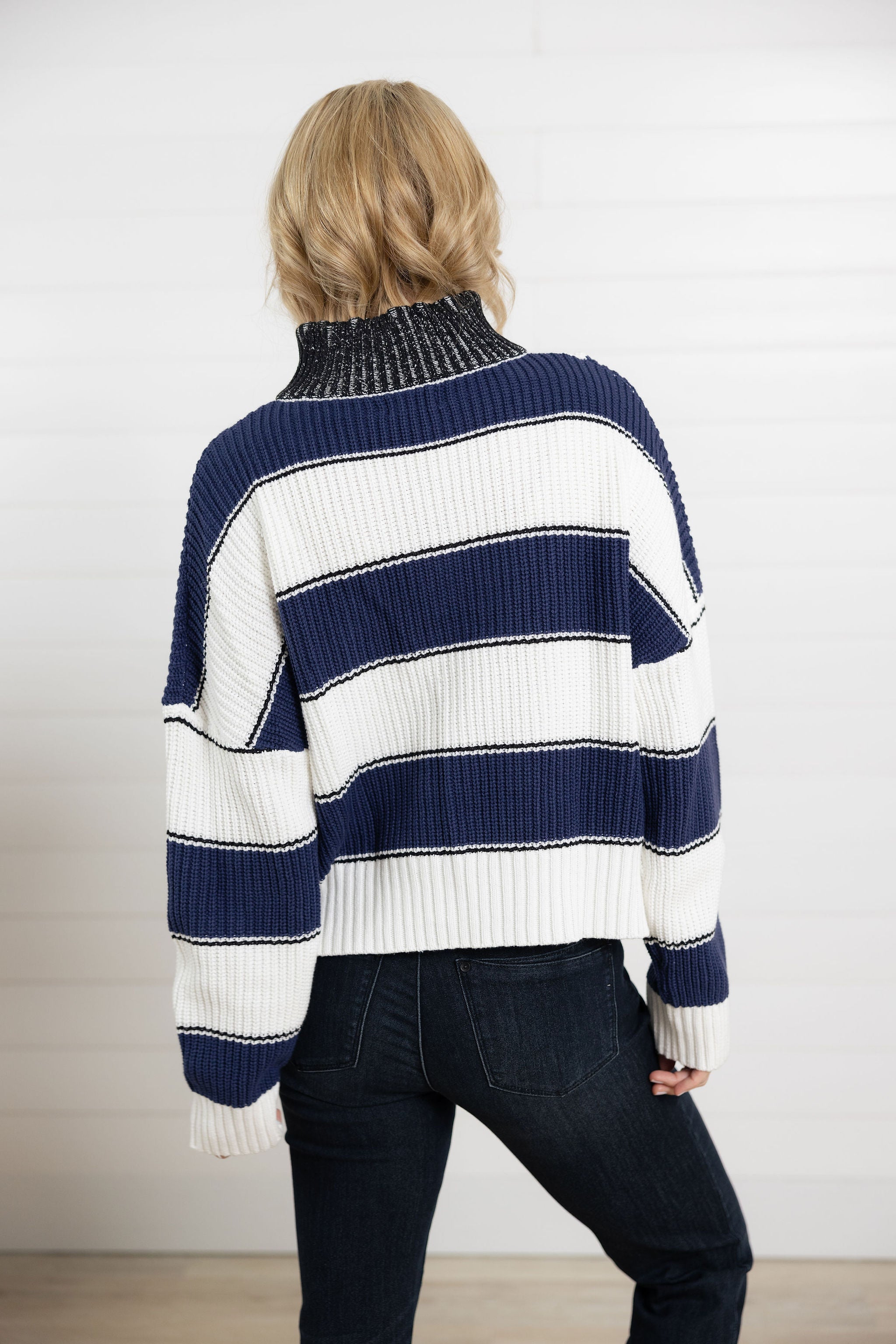 back view of wide stripe half zip sweater in navy and white with ribbed knit texture and relaxed fit